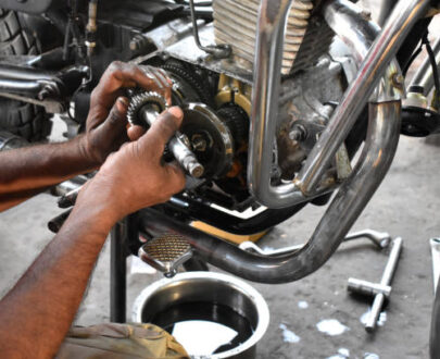 A mechanic is repairing motorbike in his motor garage, maintenance